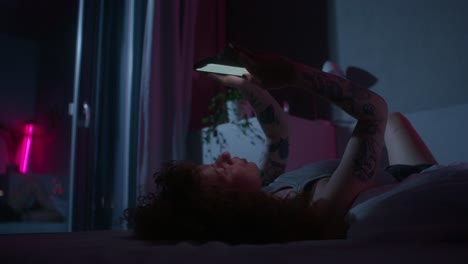 mujer usando el teléfono en la cama por la noche
