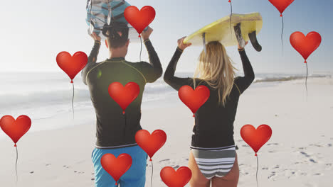 animación de globos de amor de corazón rojo iconos digitales sobre pareja llevando tablas de surf en la playa