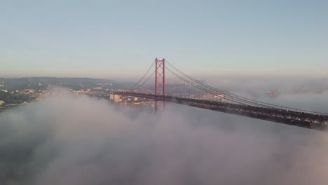 25 de abril bridge covered by morning mist in lisbon, portugal