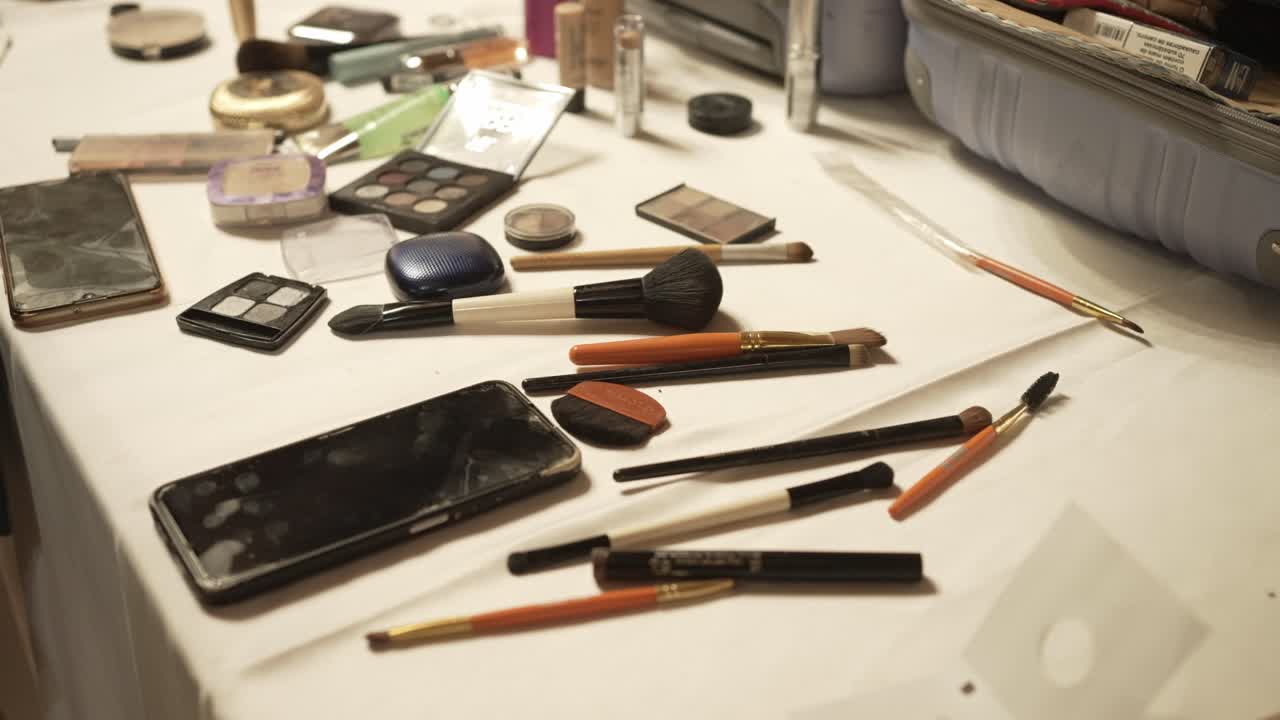Makeup tools and cosmetics scattered on a table, ready for application