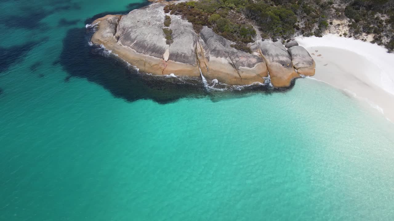 drone panorámica aérea alrededor de una pequeña playa con agua azul brillante