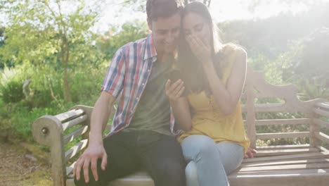 Happy-caucasian-couple-in-garden-sitting-on-bench