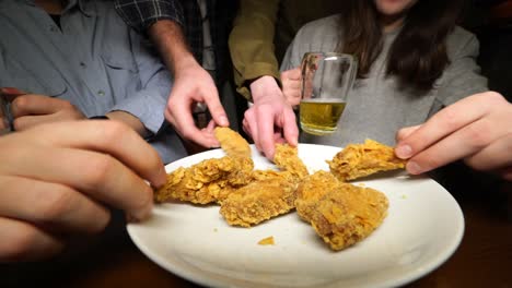 friends enjoying fried chicken and beer