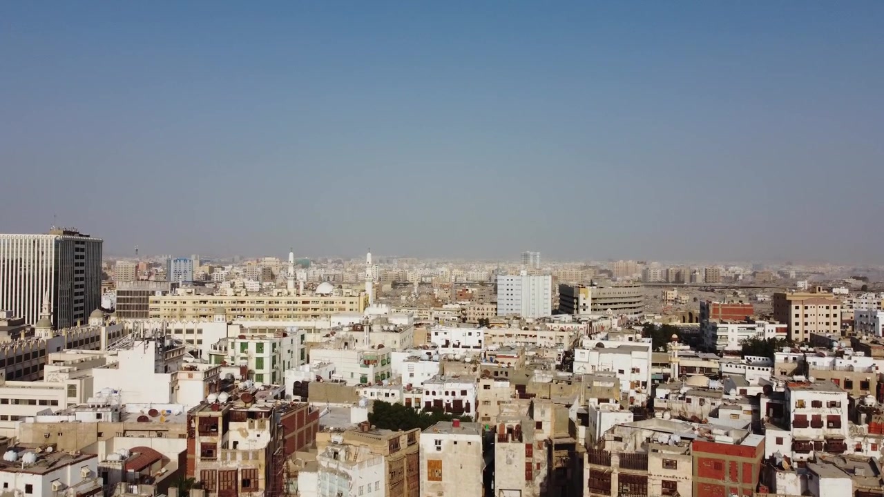 Ampia ripresa aerea panoramica di un denso paesaggio urbano con edifici residenziali tradizionali, tetti e architettura moderna sotto un cielo velato in un quartiere storico dell'Arabia Saudita