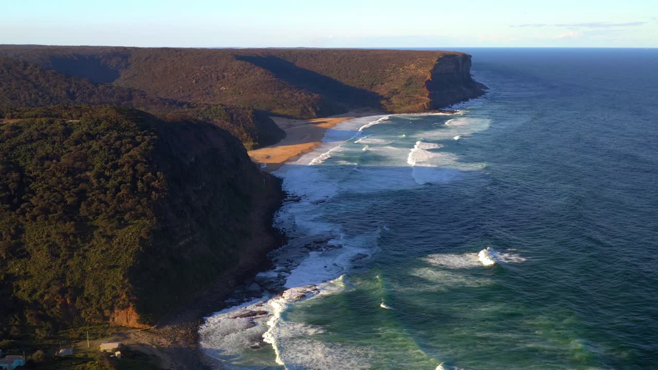 Scogliere e vegetazione che circondano Garie Beach sulla costa del Nuovo Galles del Sud, Royal National Park, Australia - ripresa aerea con drone