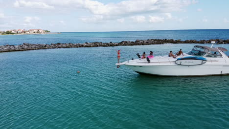 Vista-Aérea-De-Personas-De-Vacaciones-En-Un-Yate-Blanco-En-Puerto-Aventuras-En-La-Riviera-Maya,-México