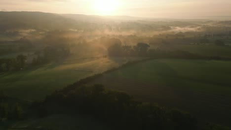 Aerial-View-of-Early-Morning-Mist-in-Rolling-Countryside---Golden-Hour