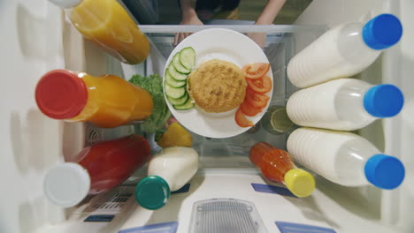 la mano de un hombre toma una hamburguesa y una salsa del refrigerador 2