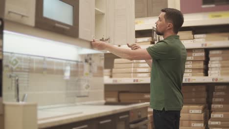 man inspecting kitchen cabinets in a store