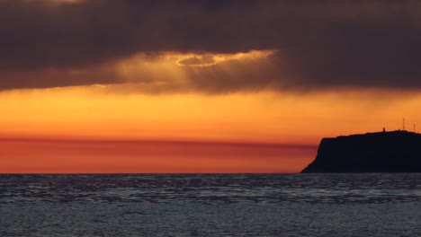 red sunset island silhouette with colorful sky sunlight reflecting on sea surface, romantic evening in mediterranean