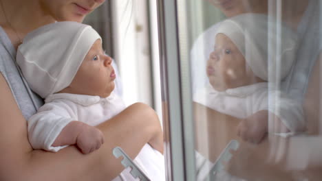 Mutter-Mit-Kleinem-Mädchen,-Das-Aus-Dem-Fenster-Schaut