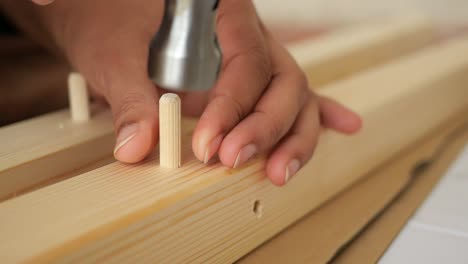 assembling wooden furniture with a hammer and dowels