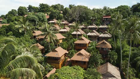 Aerial-flyover-of-a-village-on-Ko-Lipe-Island,-Thailand-nestled-amongst-the-tropical-vegetation