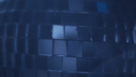 close up of a rotating blue disco ball and rising smoke