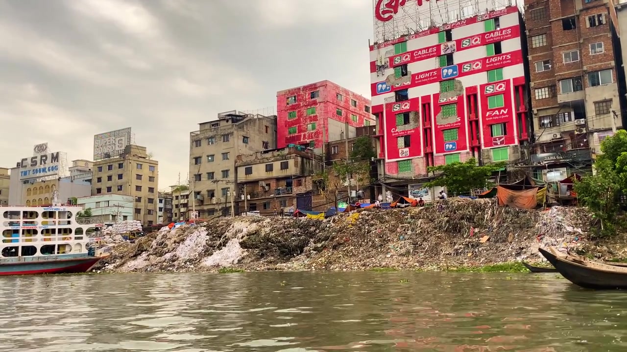 Rifiuti industriali sulla sponda del fiume Buriganga che inquinano l'acqua del fiume, contribuendo al cambiamento climatico a Dhaka, Bangladesh.