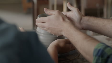 pottery class: hands shaping clay on a wheel