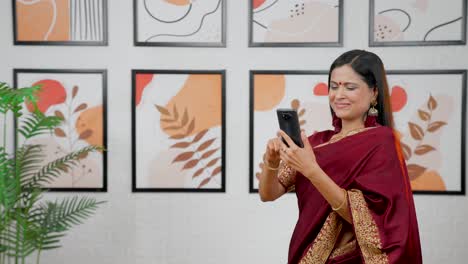 Indian-woman-scrolling-phone-with-copy-space