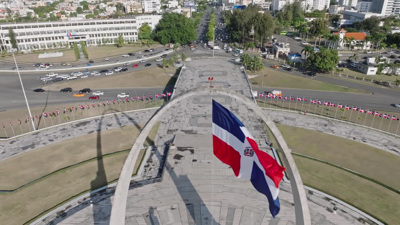 Flag waving in the wind on triumphal arch, Plaza de la Bandera at Santo Domingo city