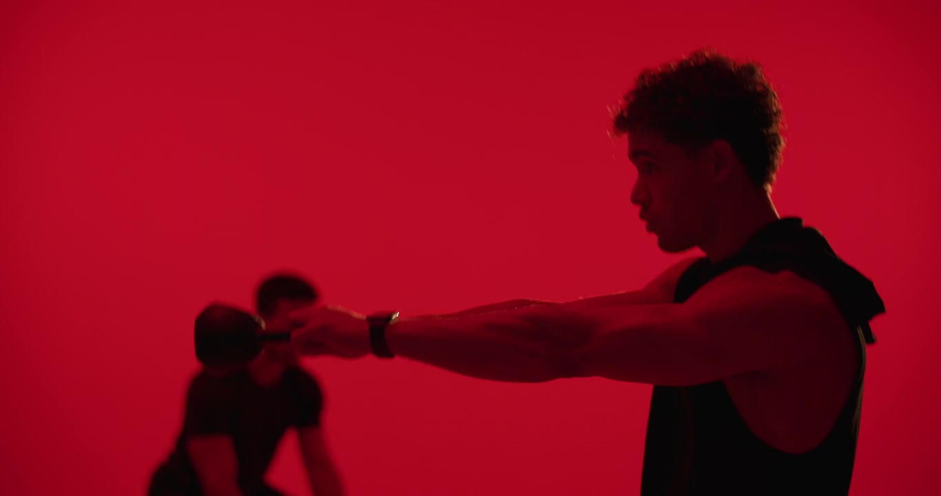 Two Men Performing Intense Workout Exercises in Red Studio