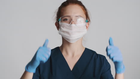 redheaded doctor in front of camera on gray background.