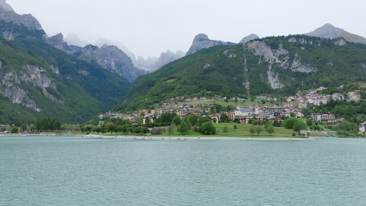 Moving forward drone footage over the lake in the Italian town of Molveno in northern Italy.