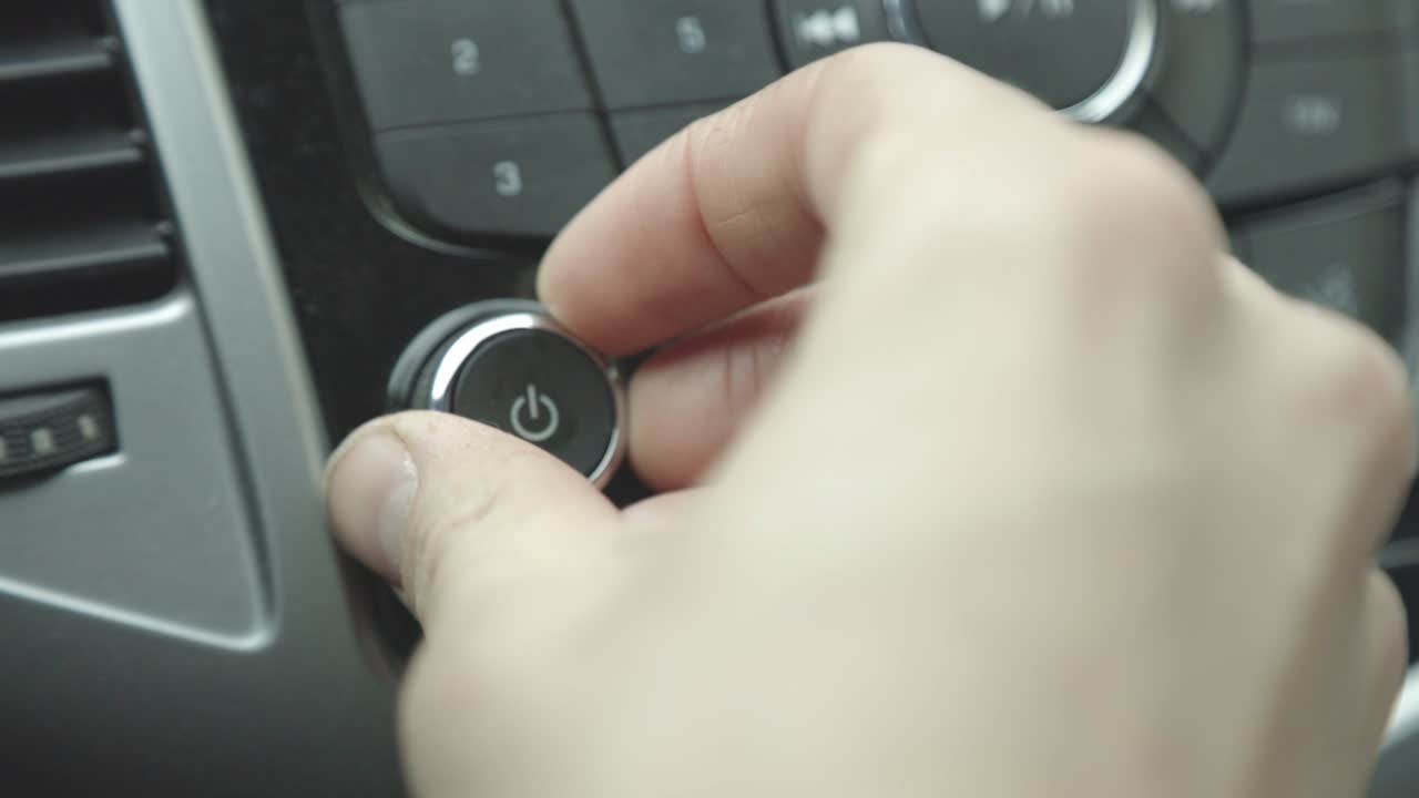 A Man's Hand Turning The Volume Of The Radio Inside The Car, Listening To Music While Driving - Closeup Shot
