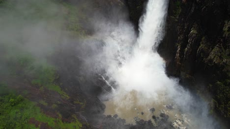 vista aérea de la caída de wallaman, la cascada más alta de australia, el agua que fluye y la niebla, disparo de avión no tripulado