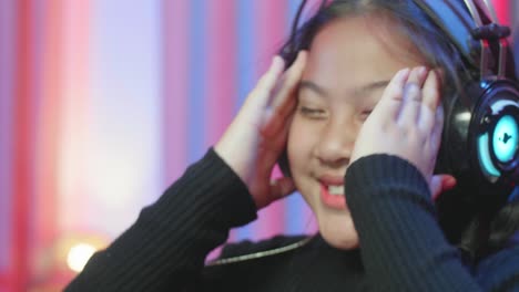girl playing video games with headphones