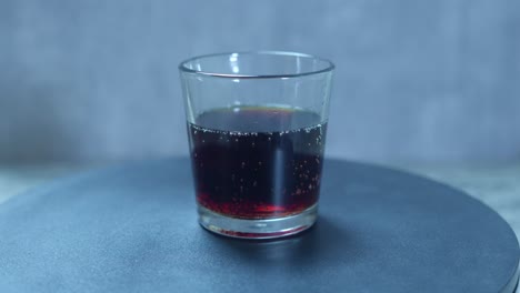 una vista de un vaso de cerveza de raíz girando de izquierda a derecha