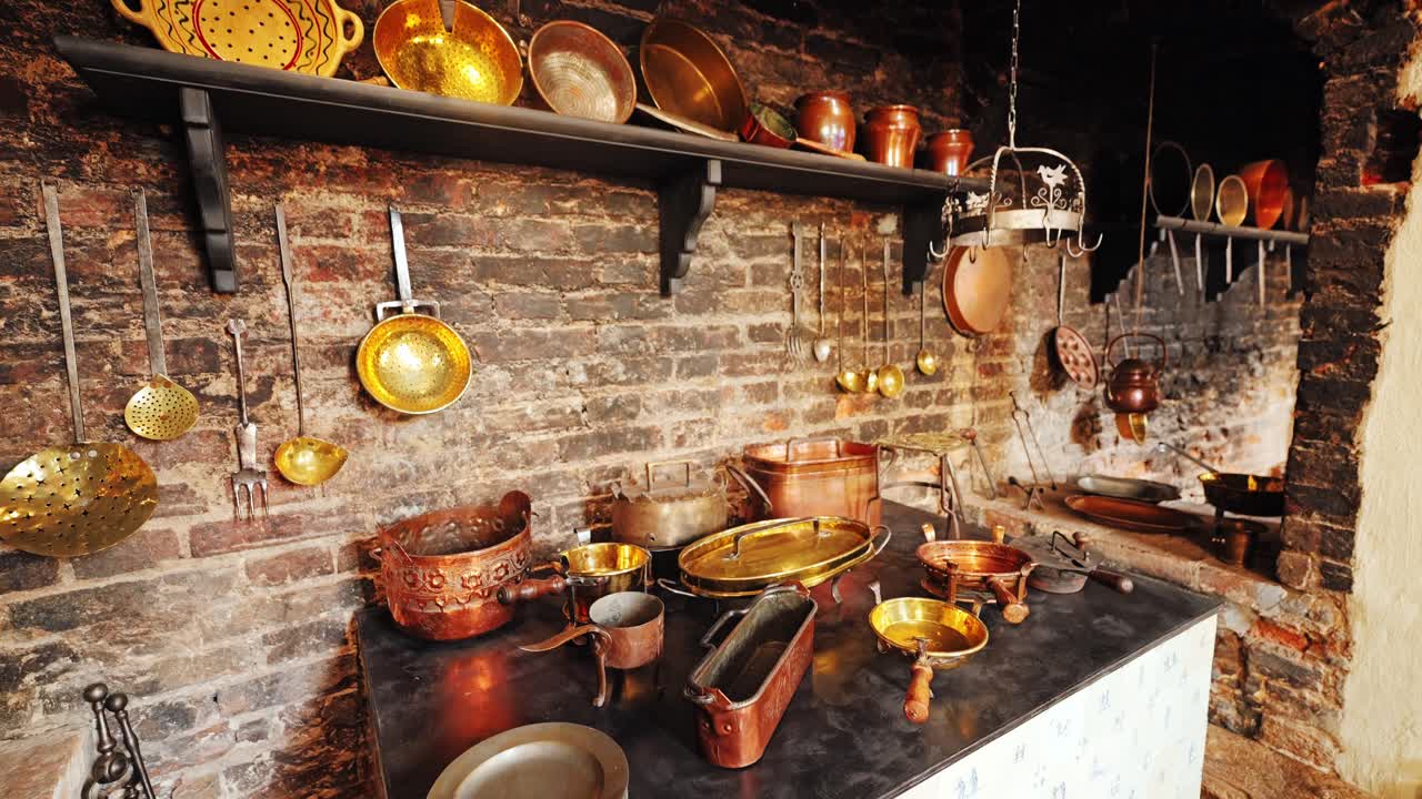 Slow tilt revealing antique copper cookware in baroque era kitchen hearth