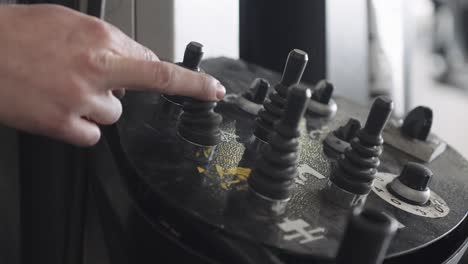 a mechanic activates a control of the tire changer in his garage