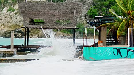 Zoom-of-local-wooden-fishing-boat-being-smashed-into-pieces-during-sudden-storm-with-rough-waves,-Caribbean