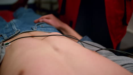 vista de cerca de las manos de los paramédicos poniendo electrodos holter en el cuerpo del hombre