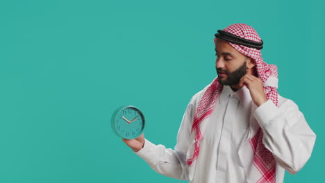 Arab-man-looks-at-clock-to-check-time