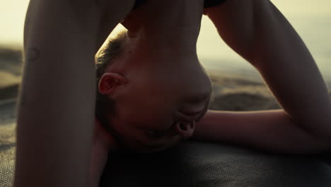 closeup yogi girl standing on head summer evening. woman making headstanding.