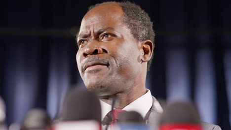 black politician speaking in microphones at press conference
