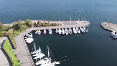 Beautiful-marina-with-many-white-yachts-anchored-on-a-calm-baltic-sea-on-a-sunny-summer-day-in-Copenhagen,-aerial-view