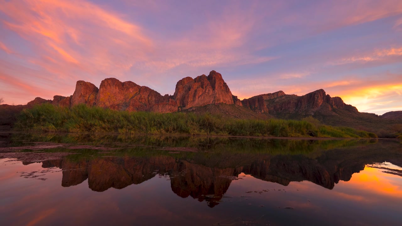 Il tramonto più vivido che si riflette sul fiume Salt nel deserto di Sonora con montagne di roccia rossa luminose.