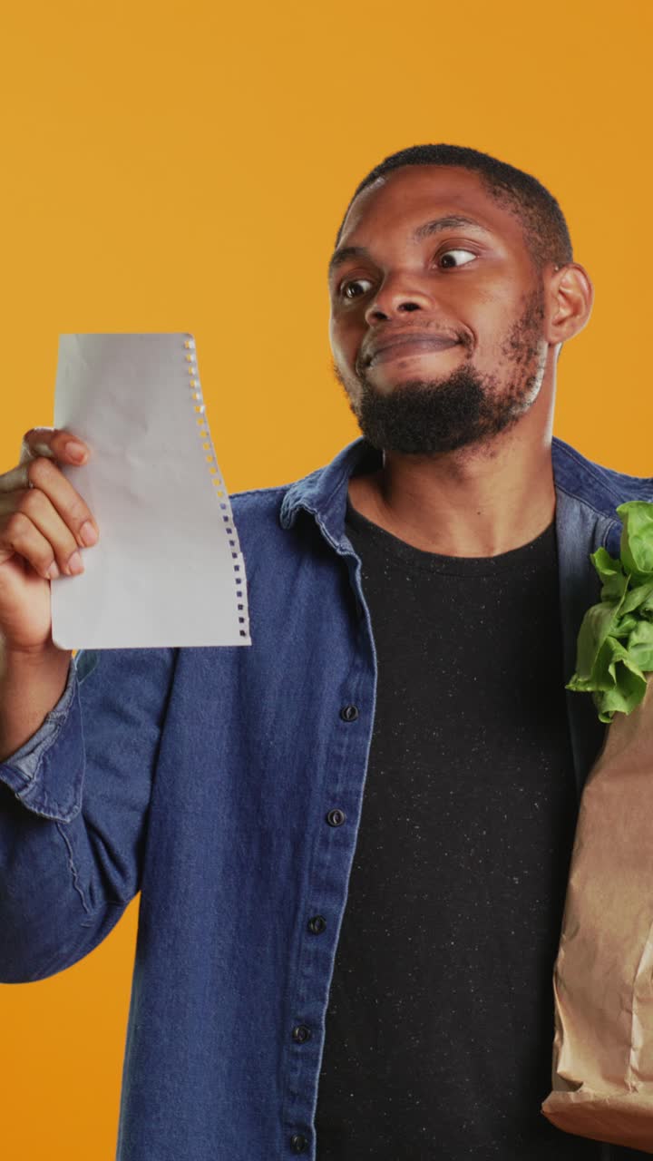 Happy Man Checking Shopping List with Fresh Groceries