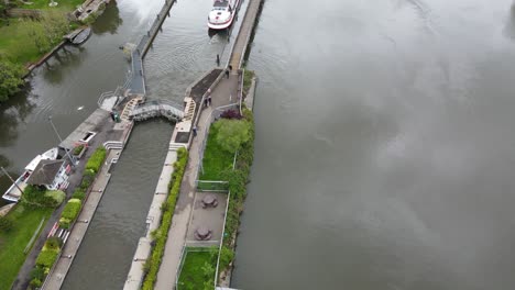 marsh lock near henley on thames large boat moving out of lock along river aerial footage