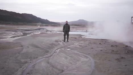 Man-standing-in-geothermal-valley-in-mountains