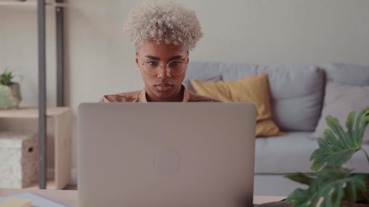 Young african american woman entrepreneur uses laptop to working internet