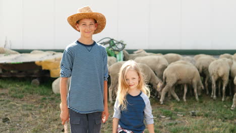 Portrait-of-Caucasian-little-girl-and-boy-standing-outdoor-at-stable-and-smiling-at-camera