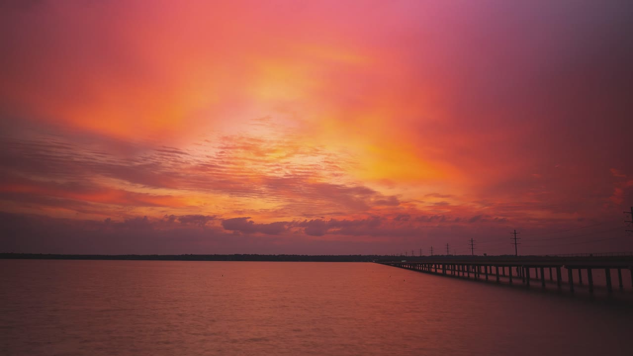 고속도로 다리 에 있는 강 을 가로질러 일몰 때 밝은 오렌지색  ⁇ 은 색조 의 서사적 인 구름 풍경