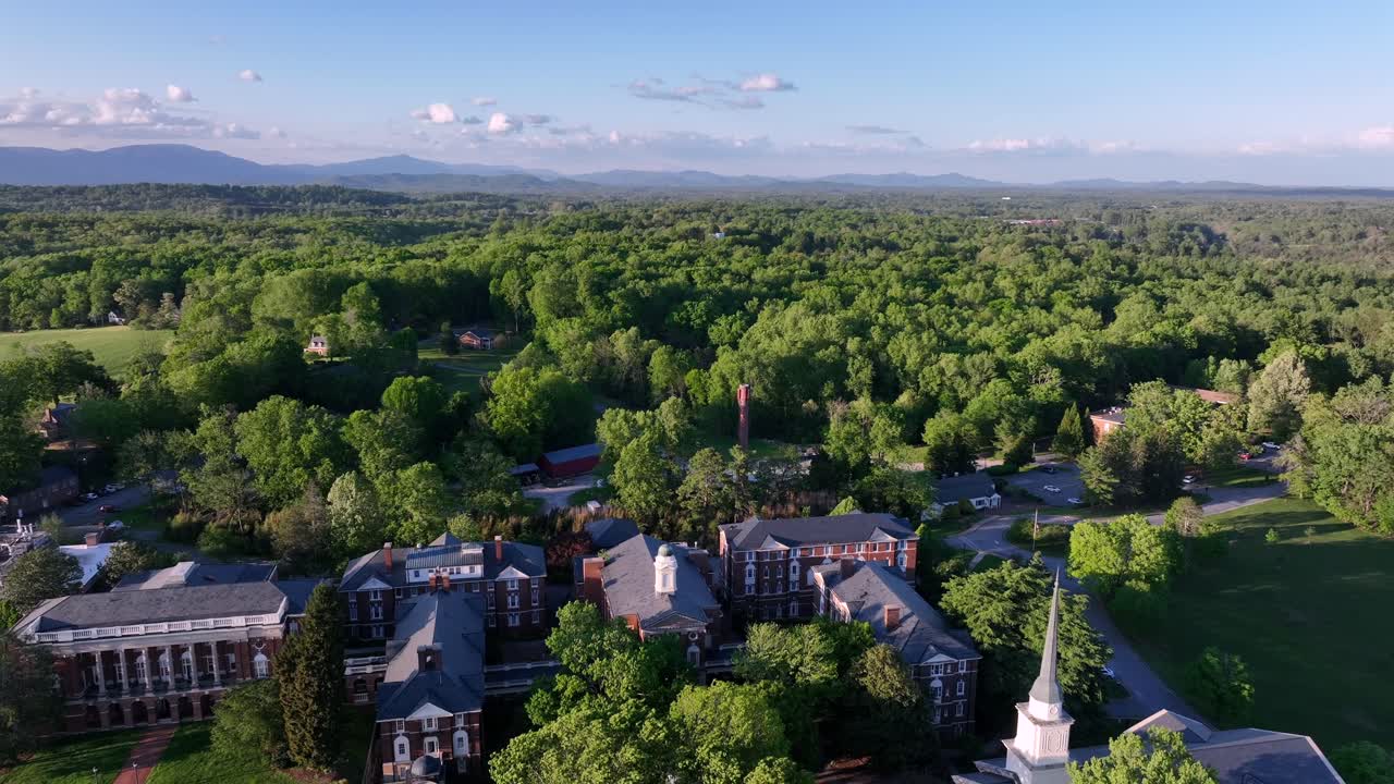 Historic School Campus in Lynchburg with church tower and green forest trees. Descend drone wide shot. Sweet briar college in Virginia.