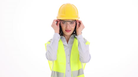 woman engineer puts on safety glasses against white background