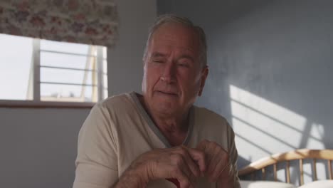 senior man lying on bed at home