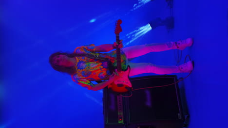 An-amazing-rock-music-player-performing.-Grunge-musician-is-playing-rock-on-bass-guitar-on-stage-making-a-cool-solo-in-red-and-blue-neon-lights.