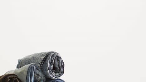 close up of folded jeans with different shades on white background with copy space