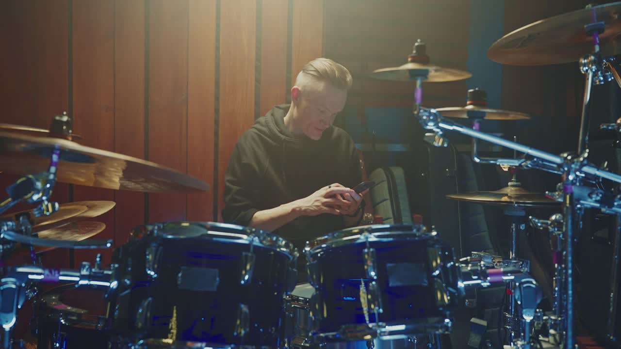 Drummer Using Phone in Recording Studio